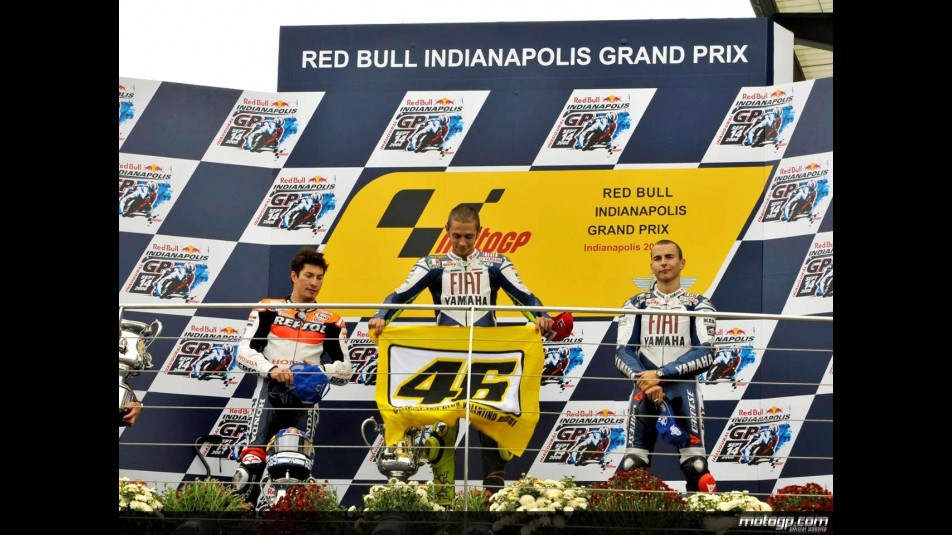 Rossi with his flag on the podium with Hayden and Lorenzo at Indianapolis