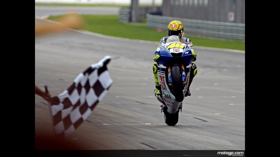 Valentino Rossi pulls off a wheelie at the finish of the race