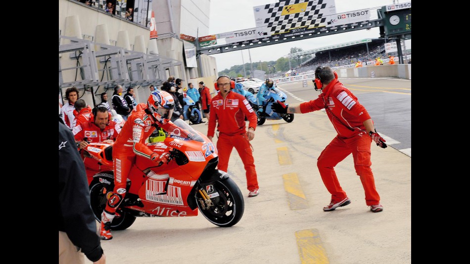 Stoner and Vermeulen during bike change in Le Mans