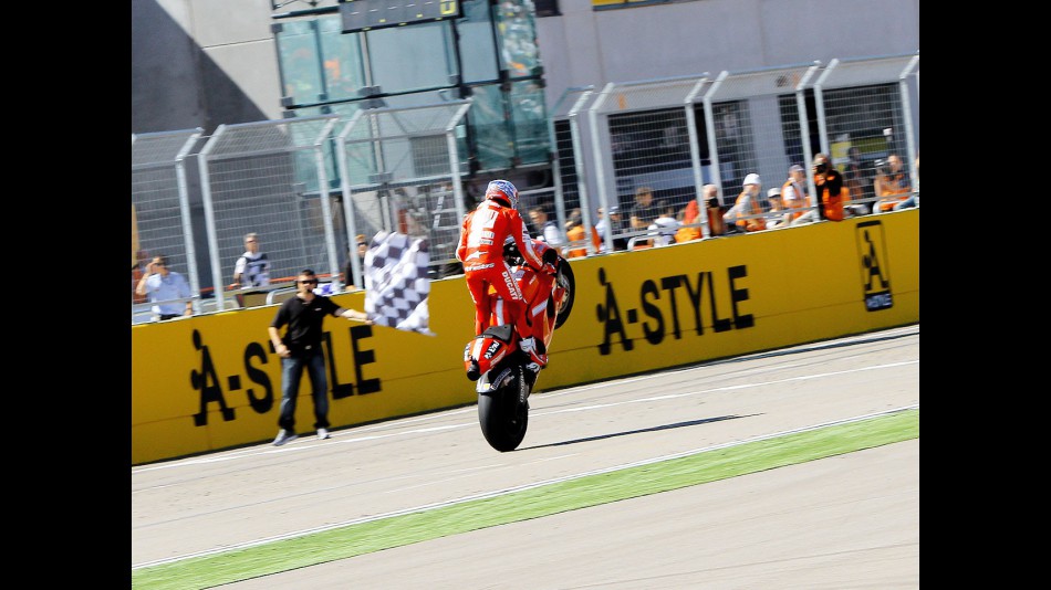 Casey Stoner pulls off a wheelie at the finish of the race at Motorland Aragón