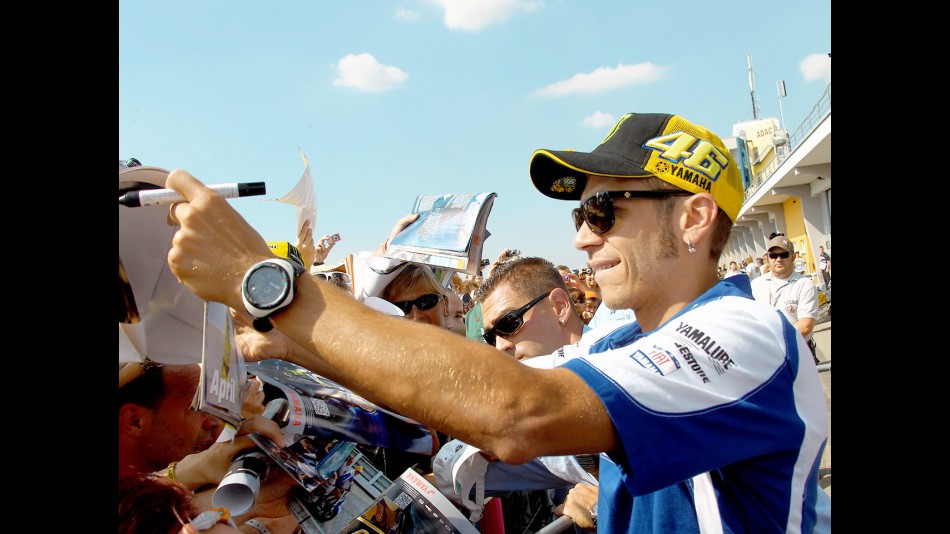 Valentino Rossi attending fans at the paddock in Sachsenring